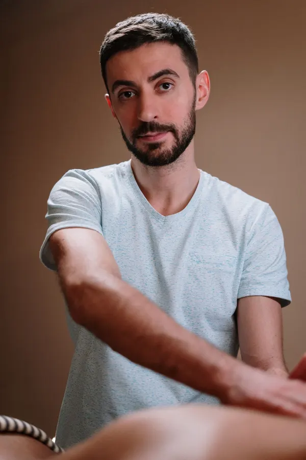 Marcus Bell giving a back massage and looking at the camera